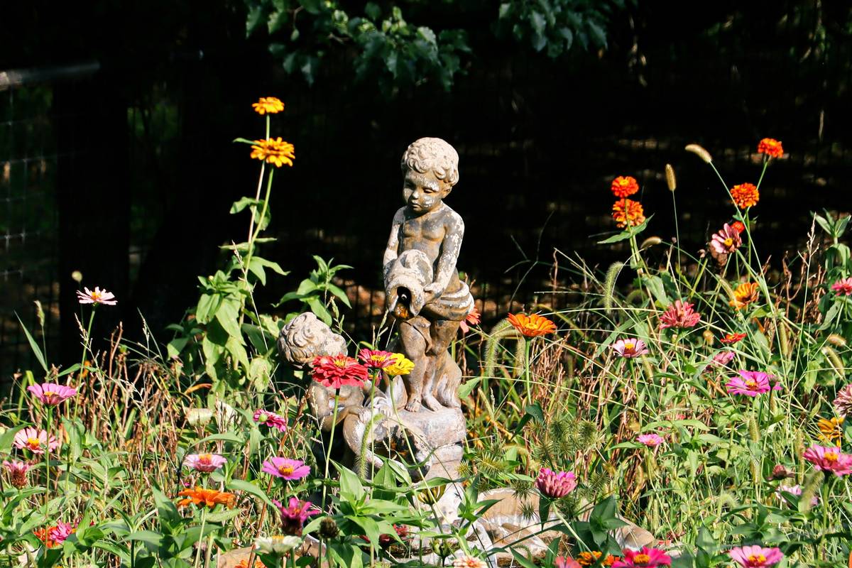 statue placement garden how to make example showing a balanced stone figure nestled among ferns near a garden path